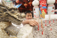 小男孩祈祷用香棍在寺庙