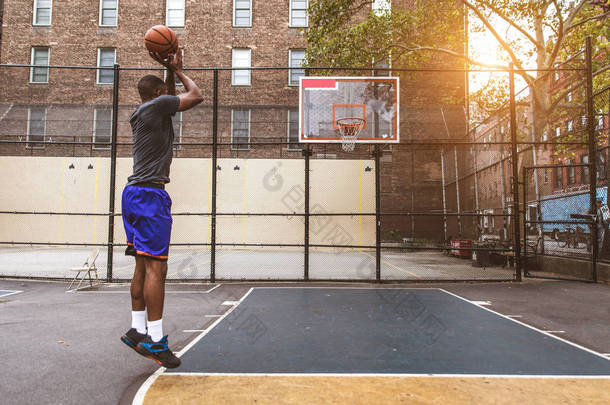 美国黑人篮球运动员在纽约的一个球场上训练——运动型男子在外打篮球