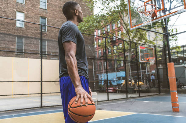 美国黑人篮球运动员在纽约的一个球场上训练——运动型男子在外打篮球