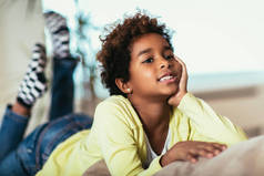 可爱的搞笑非洲小非洲裔美国女孩看着相机, 微笑的混血孩子摆姿势在家里的肖像