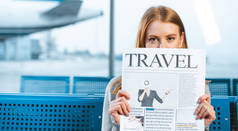 妇女覆盖脸与旅游报纸在候机大厅