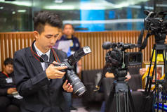 男子摄影师检查数码相机和设置的照片。技术概念.