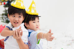 两个亚洲孩子的孩子在聚会上和朋友一起玩, 有白色的复制空间,
