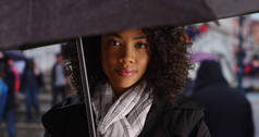 雨天威尼斯的非裔美国旅游妇女站在伞下