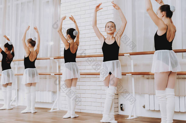 室内年轻女孩<strong>团</strong>体的芭蕾培<strong>训</strong>。古典芭蕾。巴莱丽娜·图图的女孩。室内<strong>训</strong>练。可爱的舞者大厅里的表演。舞蹈练习。穿白色衣服的女孩.
