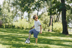 在公园里玩足球的可爱小男孩全长视图