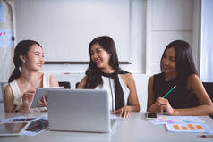 年轻的女企业家在办公室里集思广益。三美丽的亚洲妇女在办公室礼服一起谈论工作。办公室妇女在工作概念.