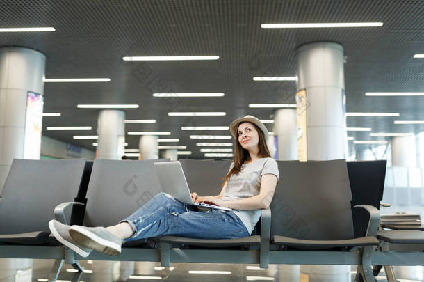 年轻的思考旅行者的旅游妇女在笔记本电脑上, 查找, 等待在大堂大厅在国际机场。周末出游的旅客<strong>出国</strong>旅行。航空旅行, 飞行旅途概念