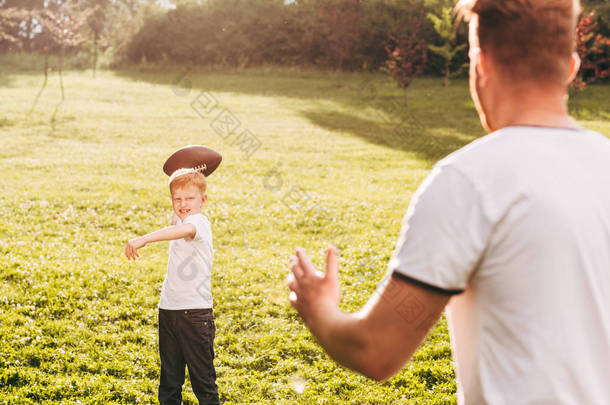 父亲和儿子在公园打橄榄球的镜头