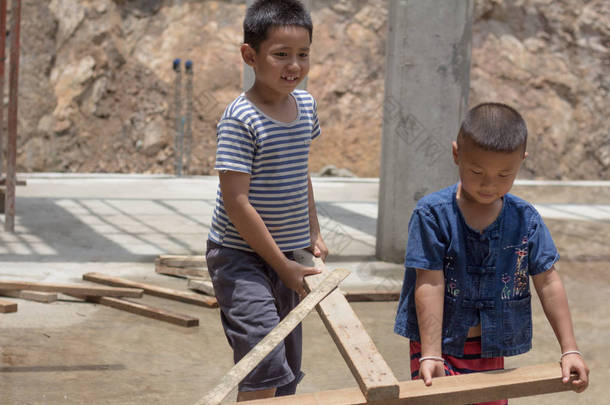 <strong>由于</strong>贫困, 两个孩子被迫从事建筑工作。暴力儿童和贩运概念, 反童工, 权利日在12月10日.
