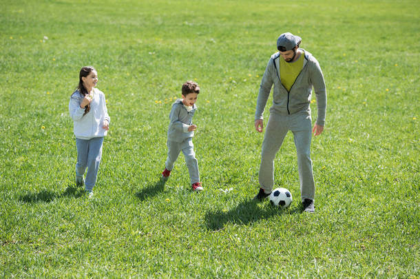 儿童与父亲在公园<strong>踢</strong>足球 