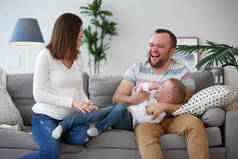 幸福怀孕的妻子, 丈夫和儿子照片在灰色的沙发上