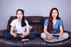 两名年轻女子使用操纵杆控制器玩视频游戏 