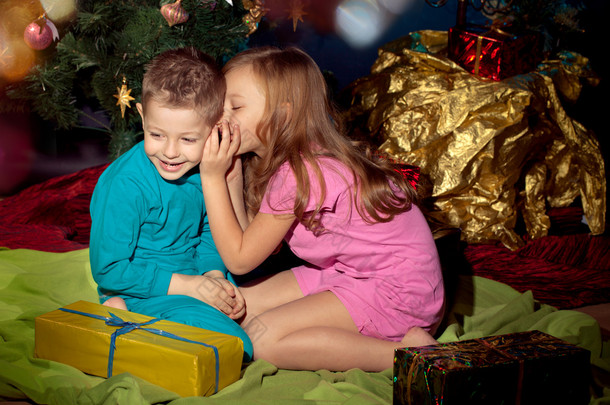 小男孩和女孩附近的圣诞树和礼物