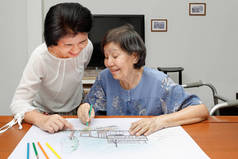 她带着女儿，在家里的爱好的绘图上的老妇绘画色彩