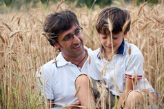 父亲和他的儿子在小麦田中玩