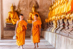 两个新手和尚走路和说话在古庙在日落的时候，大城府，泰国