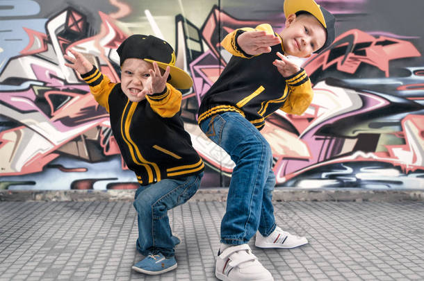 两兄弟跳舞霹雳舞。<strong>嘻哈风格</strong>。很酷的孩子。在墙上涂鸦.