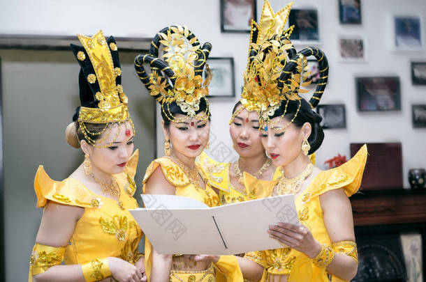 阅读与副本空间为您的文本的空白书的黄色<strong>泰国</strong>传统<strong>服饰</strong>的四个亚洲妇女女演员