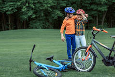 孩子们在头盔站在自行车在公园附近