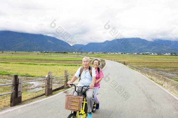 快乐高级几个骑自行车的乡村道路上