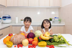快乐亚洲中国小姐妹用水果和蔬菜
