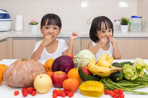 吃水果和蔬菜的快乐亚洲中国小姐妹