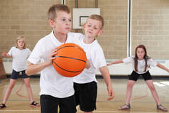 小学生在体育馆打篮球