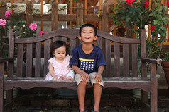 日本的弟弟和妹妹 (5 岁的小男孩和 0 岁的女孩) 坐在板凳上