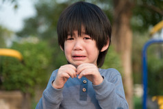 亚洲男孩在公园里哭