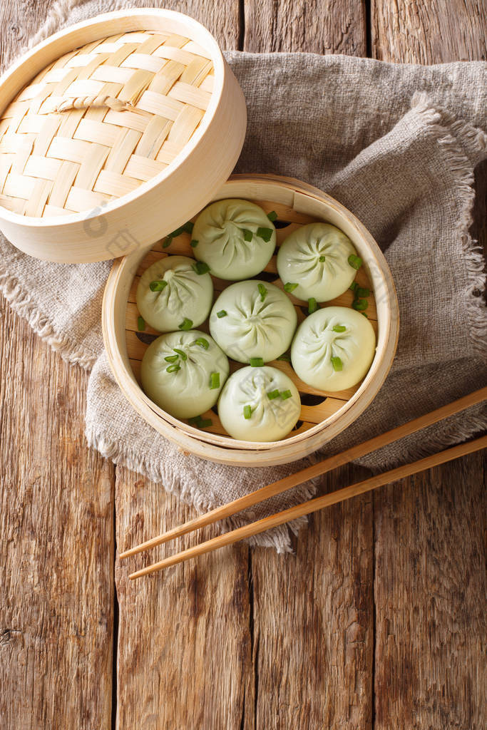 蒸煮包子中国面包在竹子蒸笼特写。 垂直t