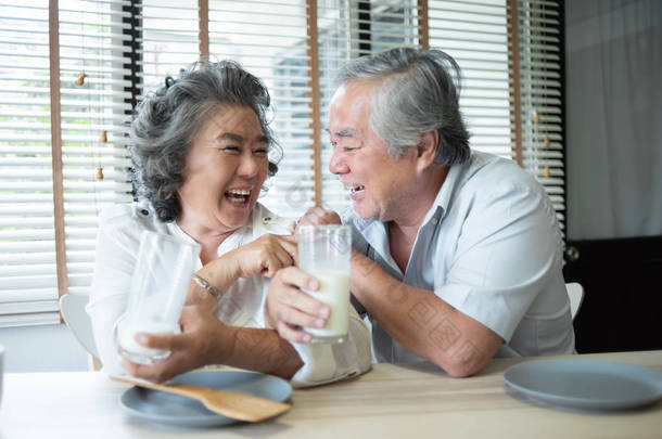 热爱喝牛奶的亚洲老年夫妇.