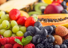 新鲜的生有机夏季浆果和异国情调的水果。宏观。闭上你的嘴菠萝、木瓜、葡萄、油桃、橘子、杏子、猕猴桃、荔枝、樱桃和植物、覆盆子.