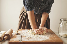 女人在木板上揉面团做意大利面