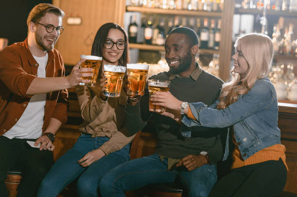 愉快的多元朋友一起喝啤酒在酒吧  