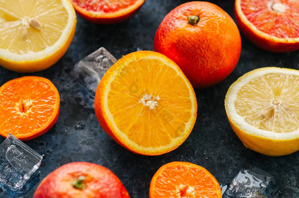 混合新鲜成熟的柑橘类水果为血橙, mandarines, 柠檬与<strong>冰块</strong>在蓝色的石头背景。顶部视图.