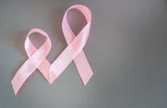 两个粉红丝带提高认识关于乳腺癌，灰色的背景上的图像复制空间