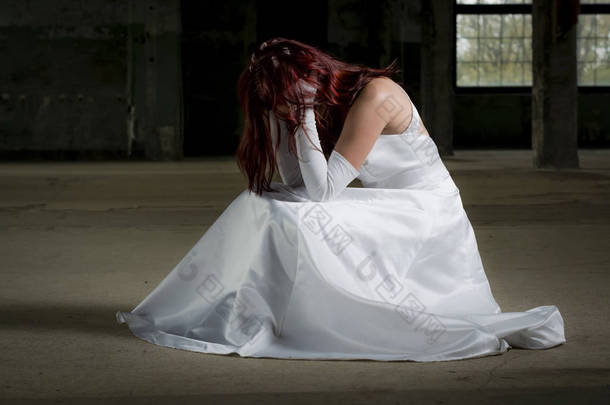 年轻的新娘坐在一幢老楼，已感到遗憾的是她的 dec