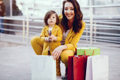 在城市里带购物袋的母亲和女儿