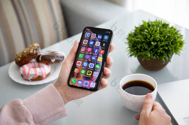 阿卢什塔, 俄罗斯-2018年9月28日: 妇女手持 iphone X 与社交网络信使在屏幕上。iphone 10 是由苹果公司创建和开发的。.