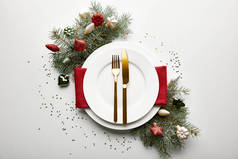 装饰松枝和五彩纸屑的白色背景圣诞餐桌的顶视图