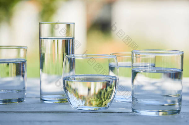在透明的玻璃杯中清澈的淡水，在木制桌子上的<strong>阳光下</strong>