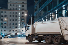 白色卡车在夜城市在现代大厦旁边.
