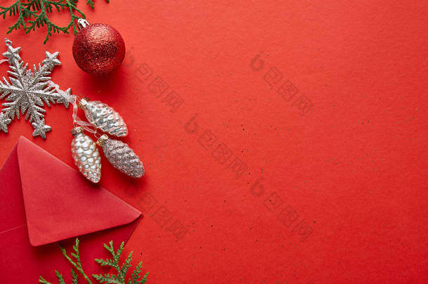 明亮的圣诞装饰、信封及带有复印空间的红色背景照片