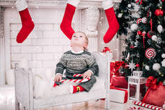 一个小男孩在壁炉和圣诞树周围舒适气氛的圣诞画像