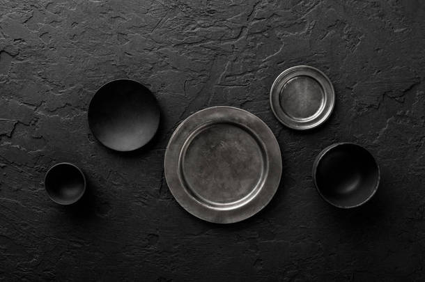 黑色石材背景黑色和灰色空盘子和碗的顶部视图