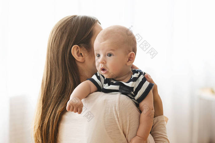 妈妈在喂奶后拍拍可爱的婴儿的背