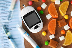 数字嘉, 注射器, 柳叶刀笔和糖果在桌上。糖尿病饮食