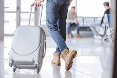 低段年轻的旅行者与手提箱在机场航站楼