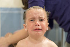 在浴缸里哭泣的婴儿。婴儿洗澡时 sreaming。婴儿在浴室哭泣.